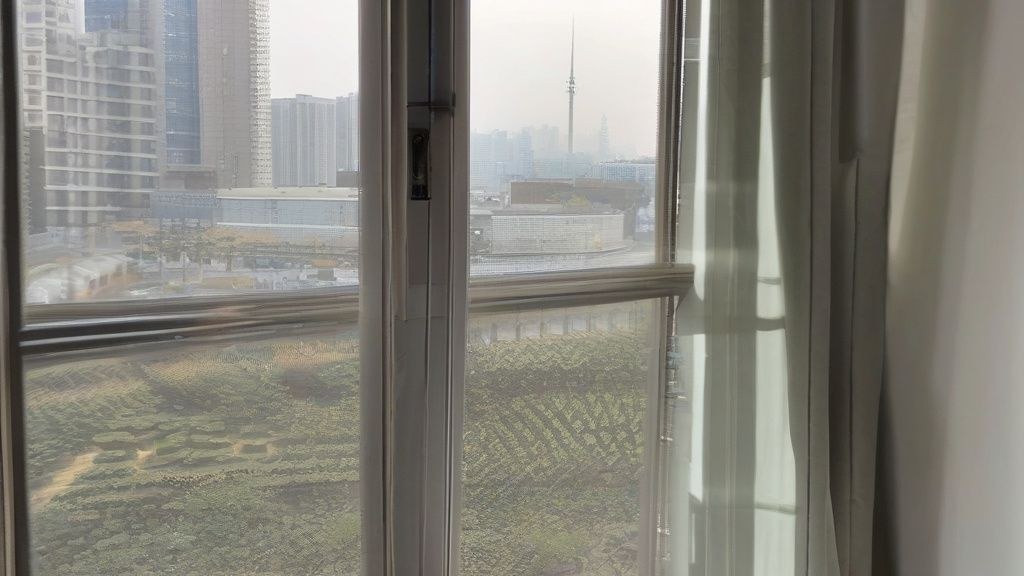 한국 가정집 거실에서 에어컨 리모컨으로 희망 온도를 조절하는 모습